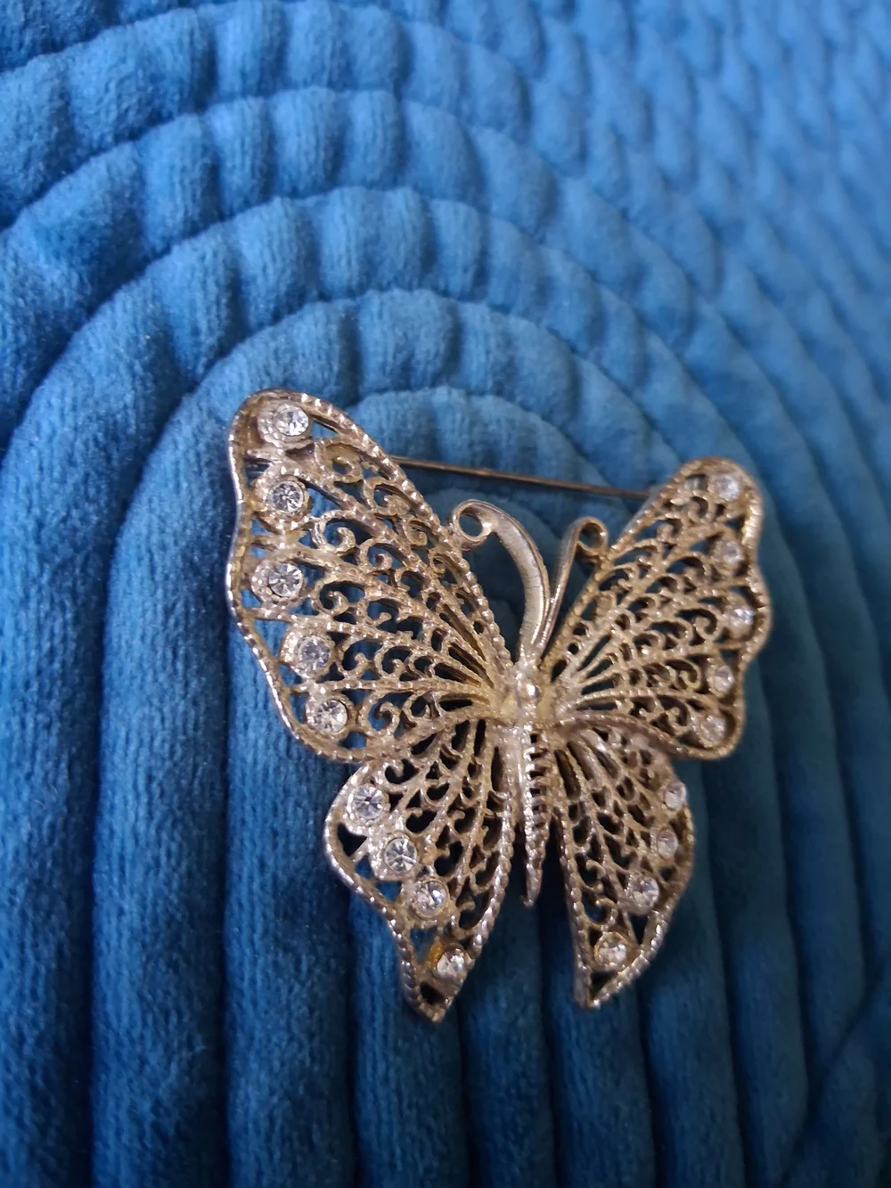 Vintage silver-tone filigree butterfly brooch adorned with rhinestones